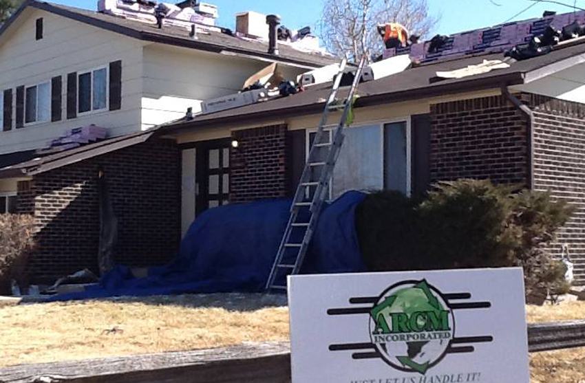 Roof cleaning technician removing debris from shingles