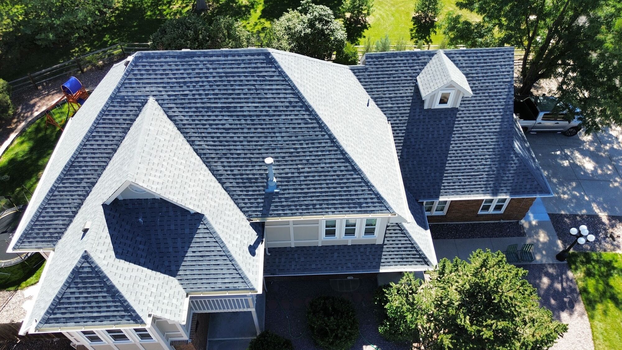 Aerial view of a two-story home with a new architectural asphalt shingle roof